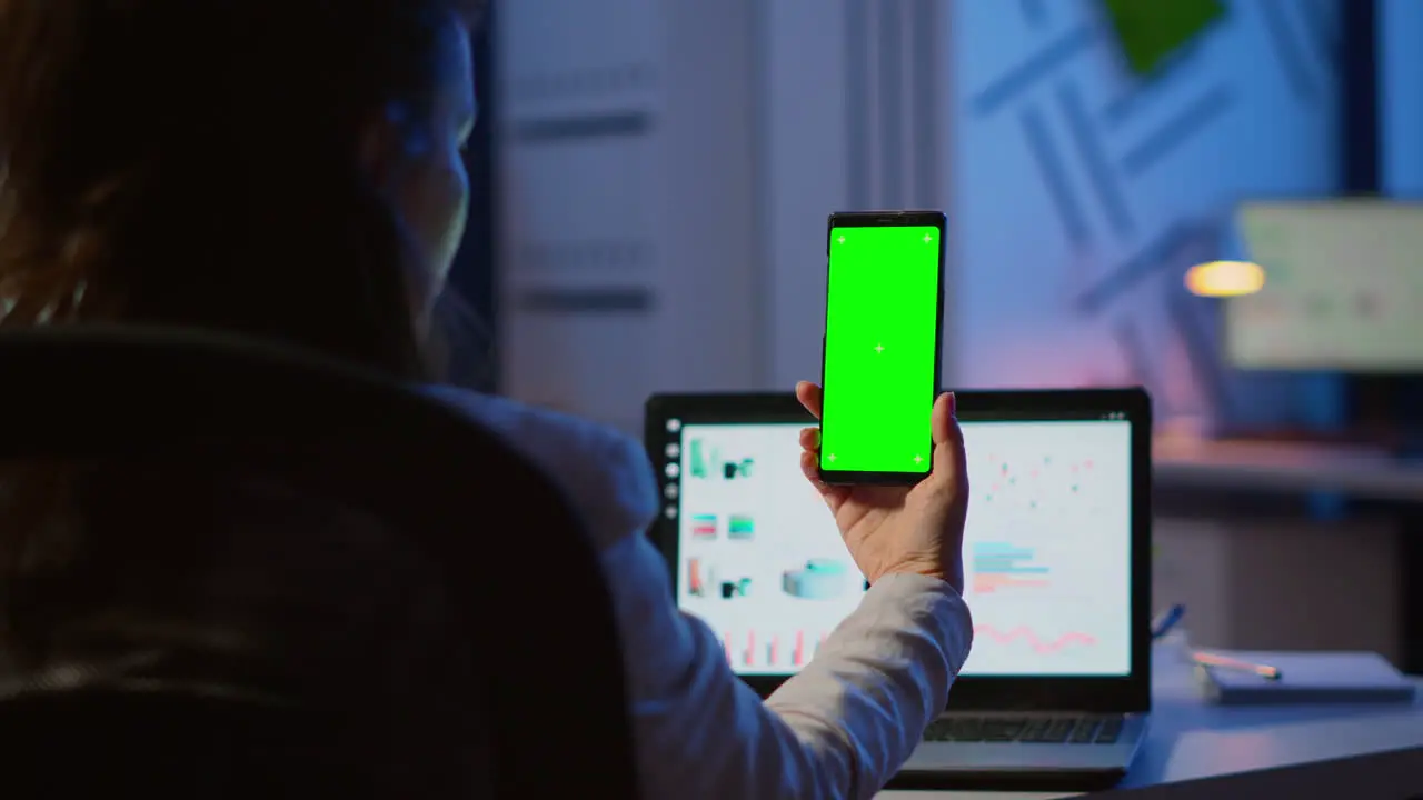 Woman employee looking at smartphone with chroma key