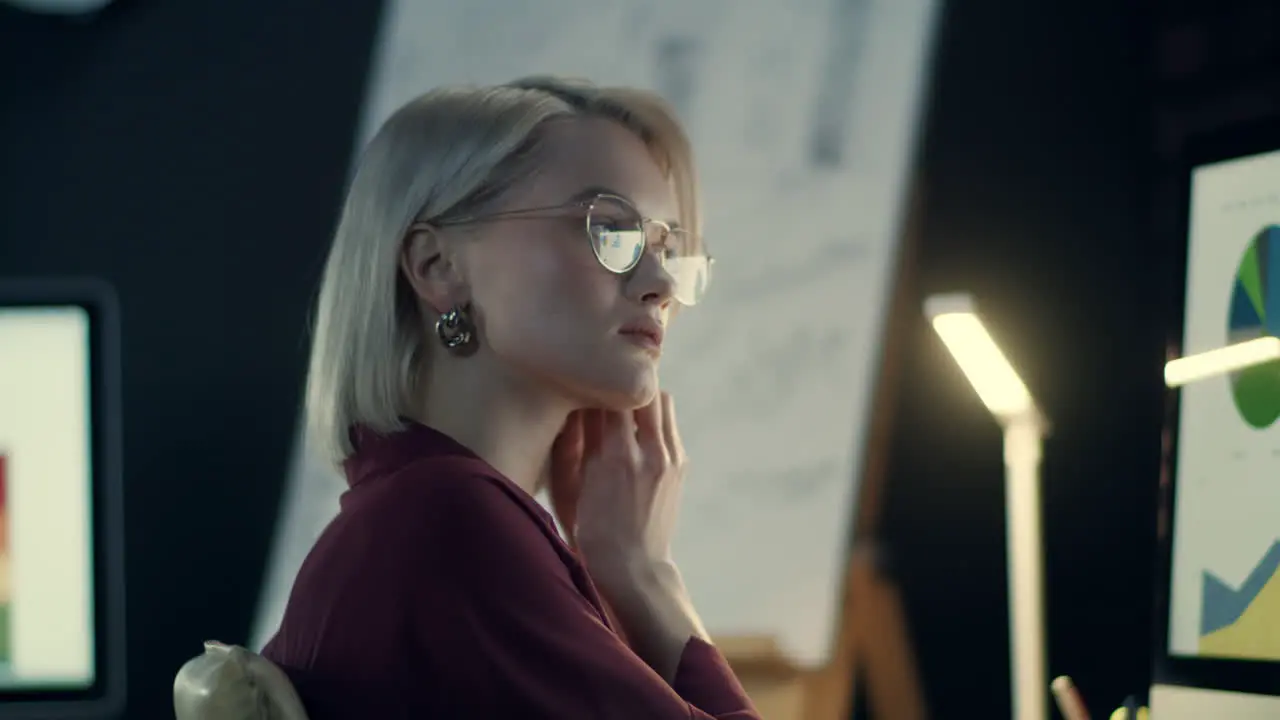 Overworked business woman fixing earring front computer in night office