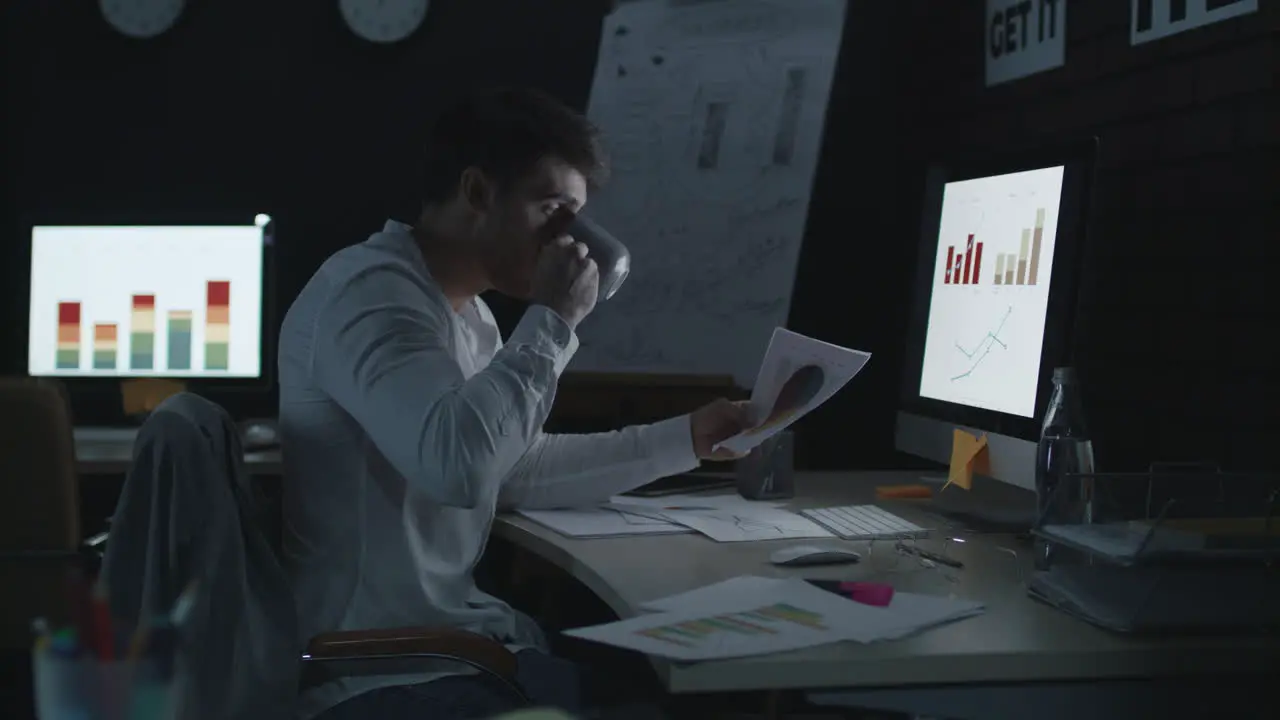 Serious businessman working on computer in night office