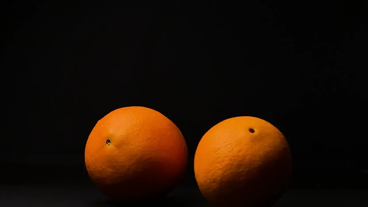 Rolling orange fruit black background