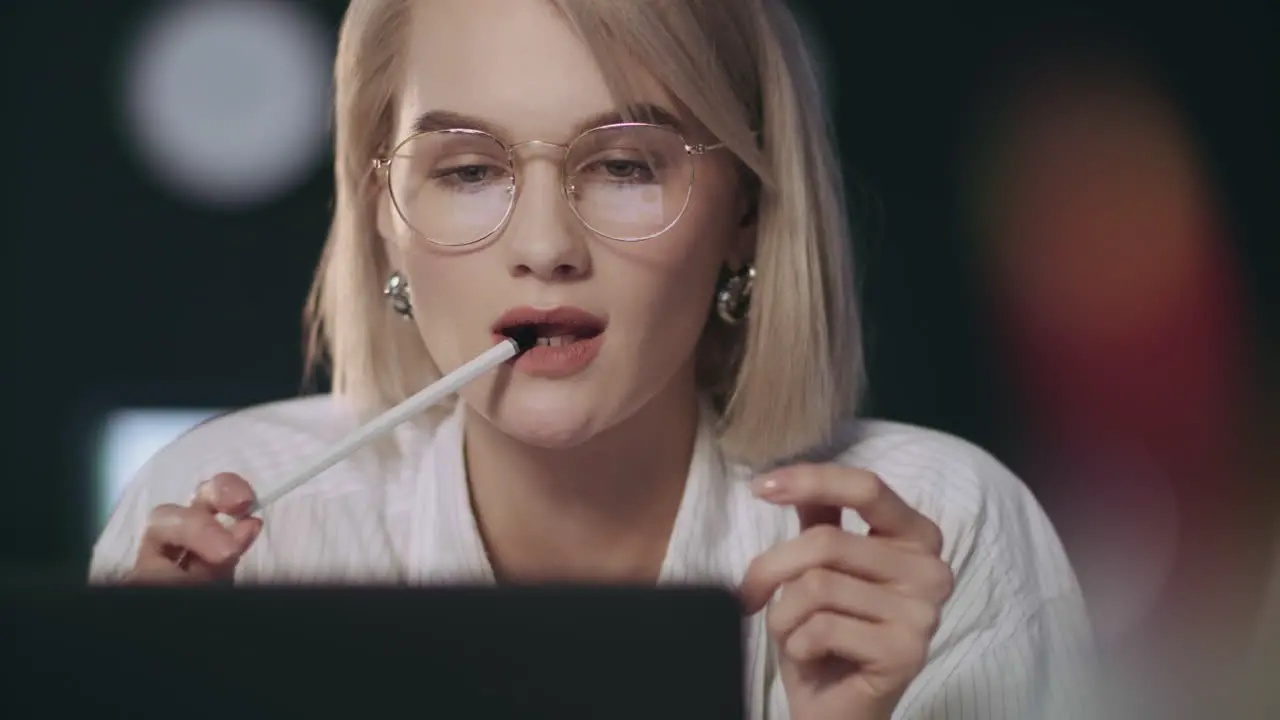 Concentrated business woman looking laptop screen in dark office