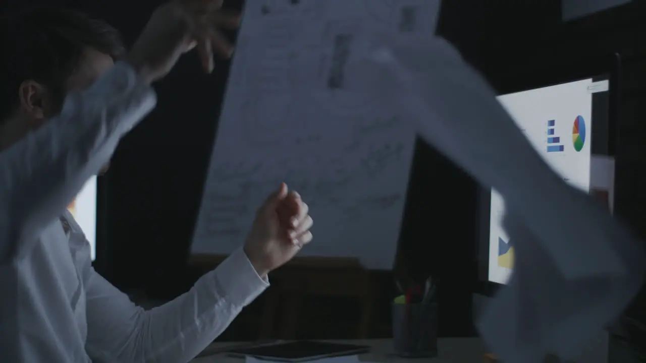 Evil business man throwing data document on computer table in dark office