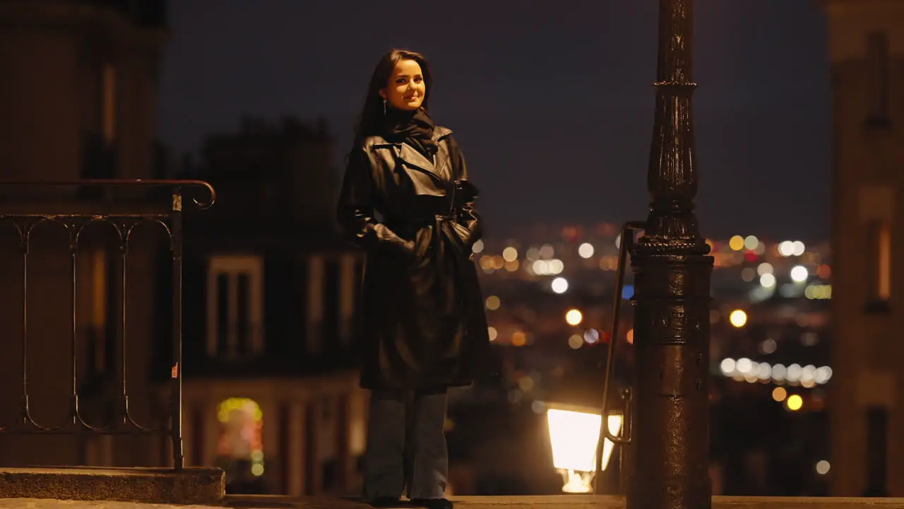 Brunette Model Woman Standing Alone Outside in Paris City By Night Dressed in Black Coat