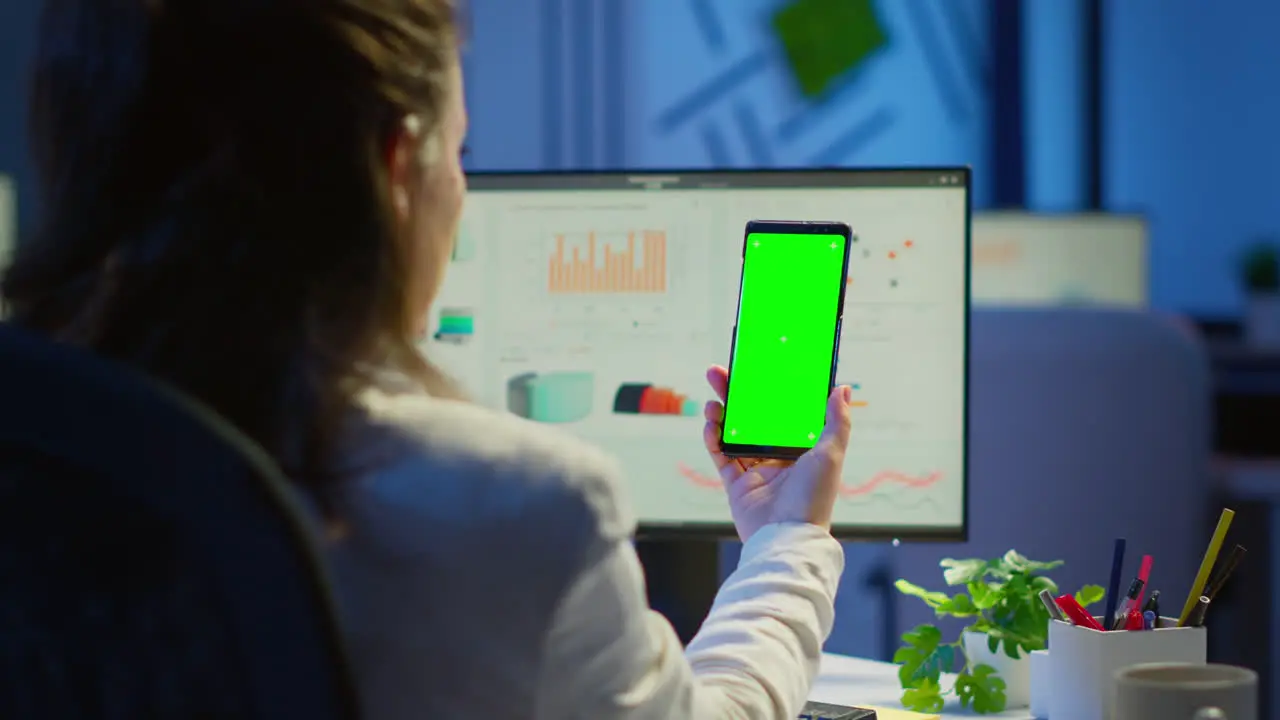 Businesswoman looking at green screen monitor of smartphone