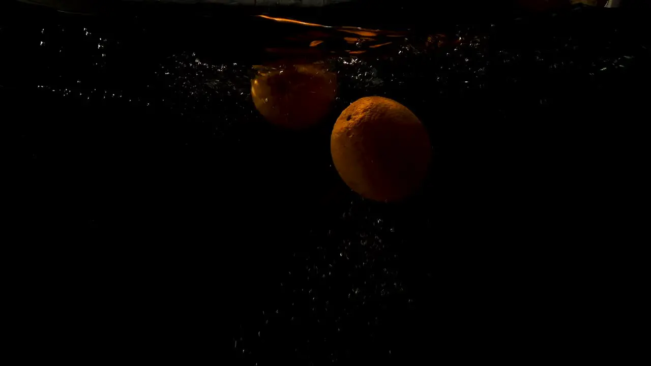 Orange Dump Into The Water And Slowly Rising Close Up Shot