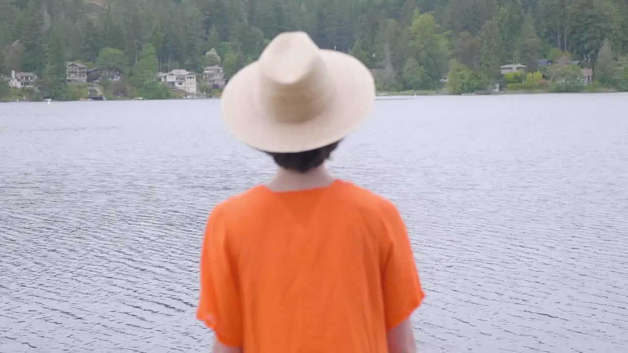 Woman in Vibrant Orange Dress Walking out the the Lake Rear Shot