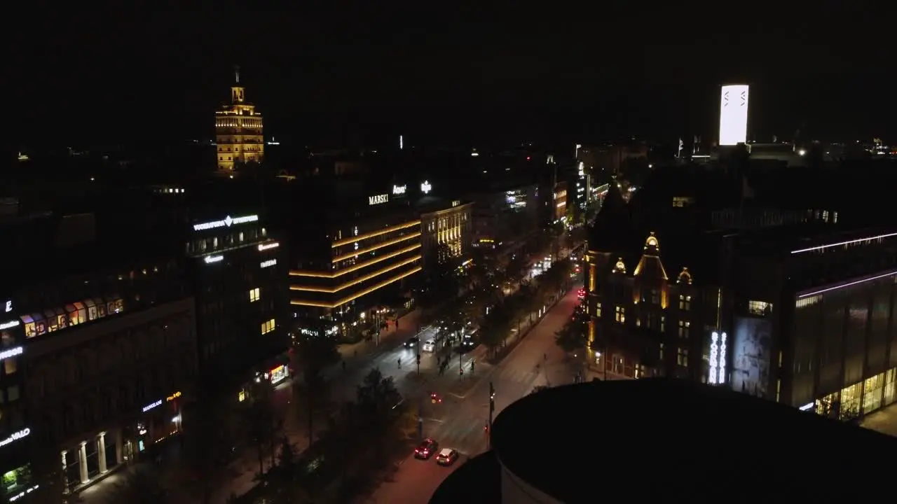 Night aerial rises over downtown retail district in Helsinki Finland