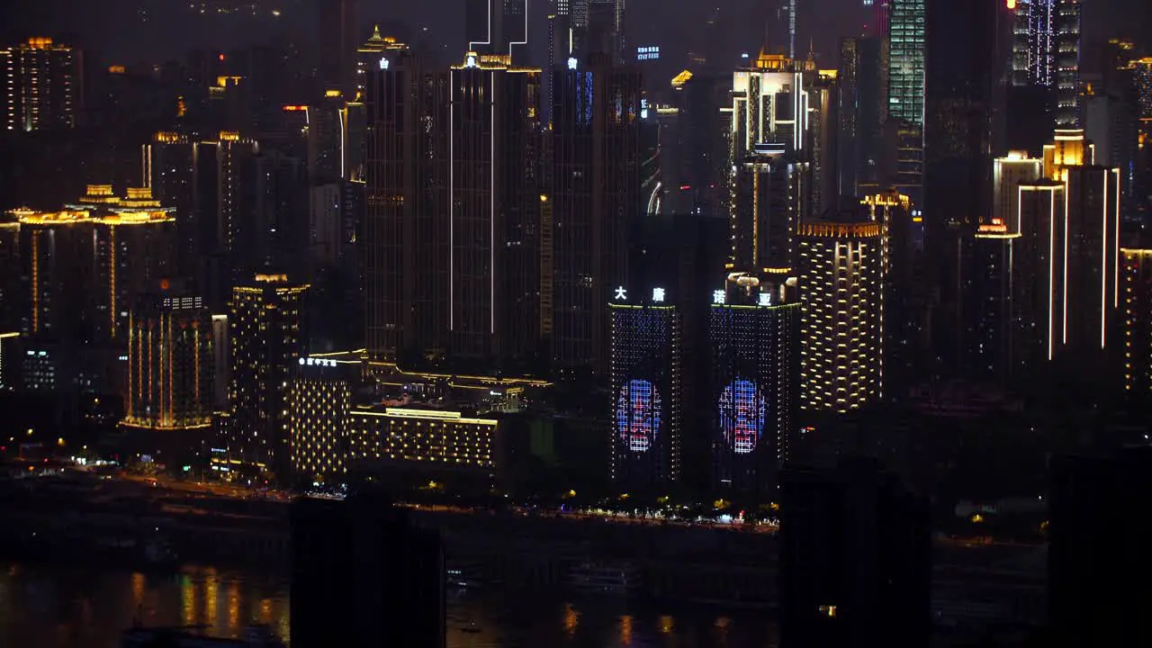 Skyline of the city at night showing window projection on buildings by the Jialing river Handheld establishing shot