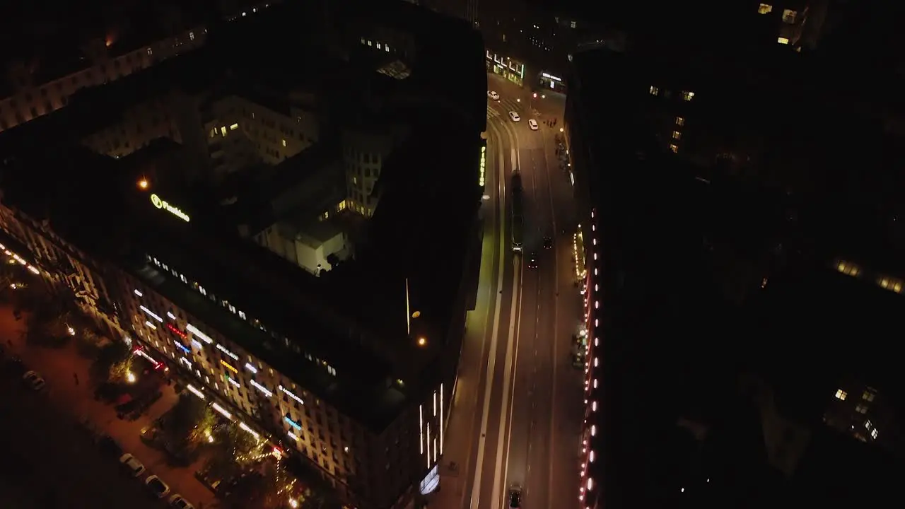 Aerial follows traffic on winding illuminated Helsinki street at night