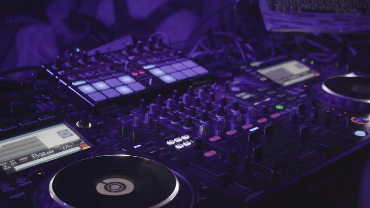 A backstage shot of the DJ using his equipment in front of a crowd