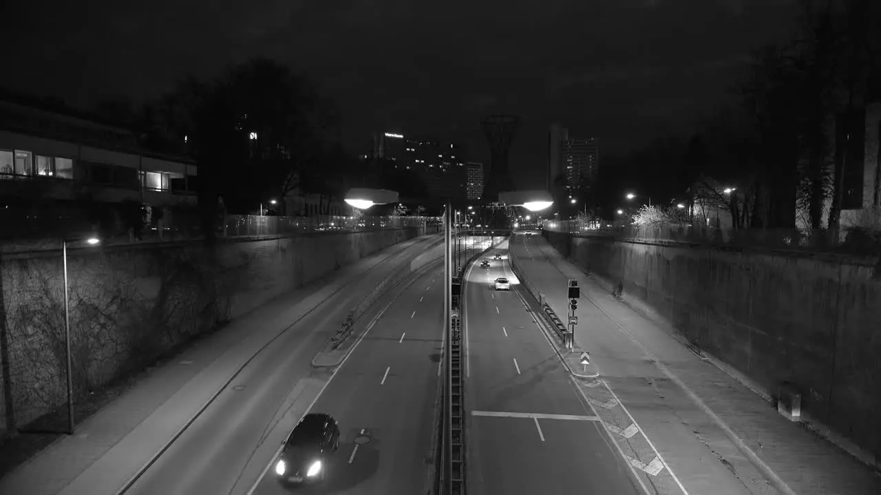 Rush hour at the night in Munich city in black and white with car traffic of a street with many tracks in both directions