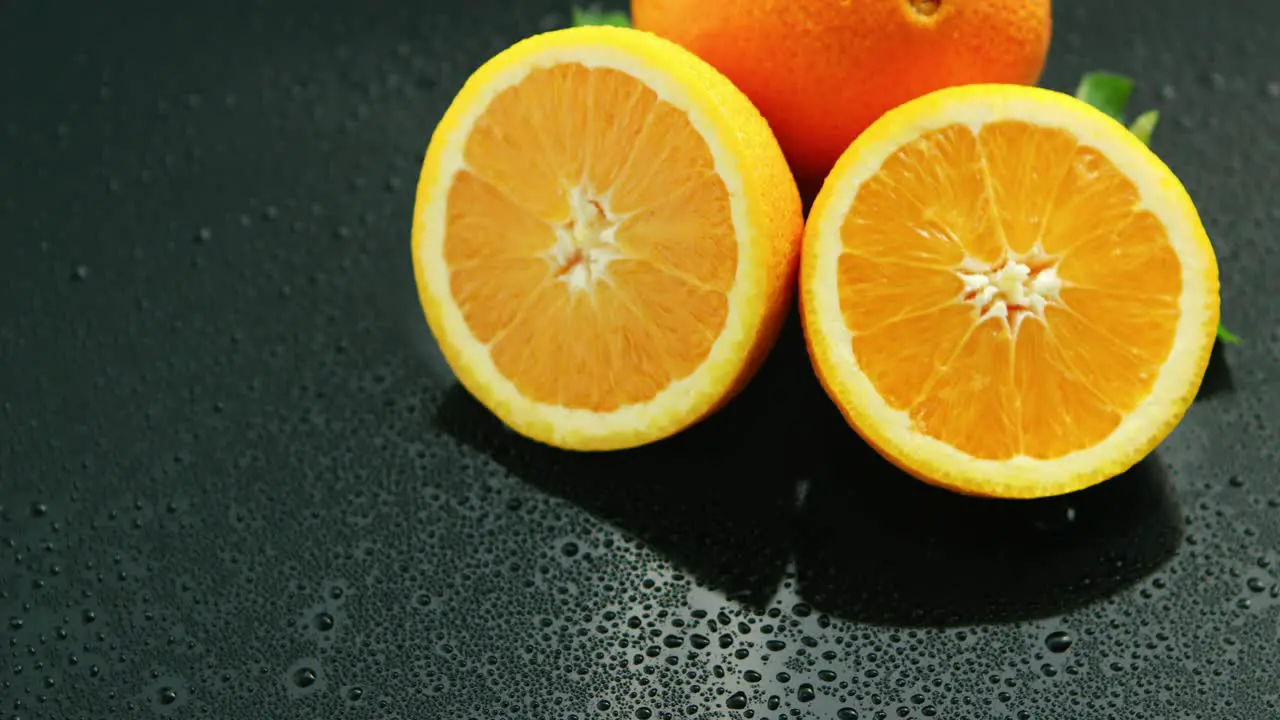 Orange with leaf on wet table 