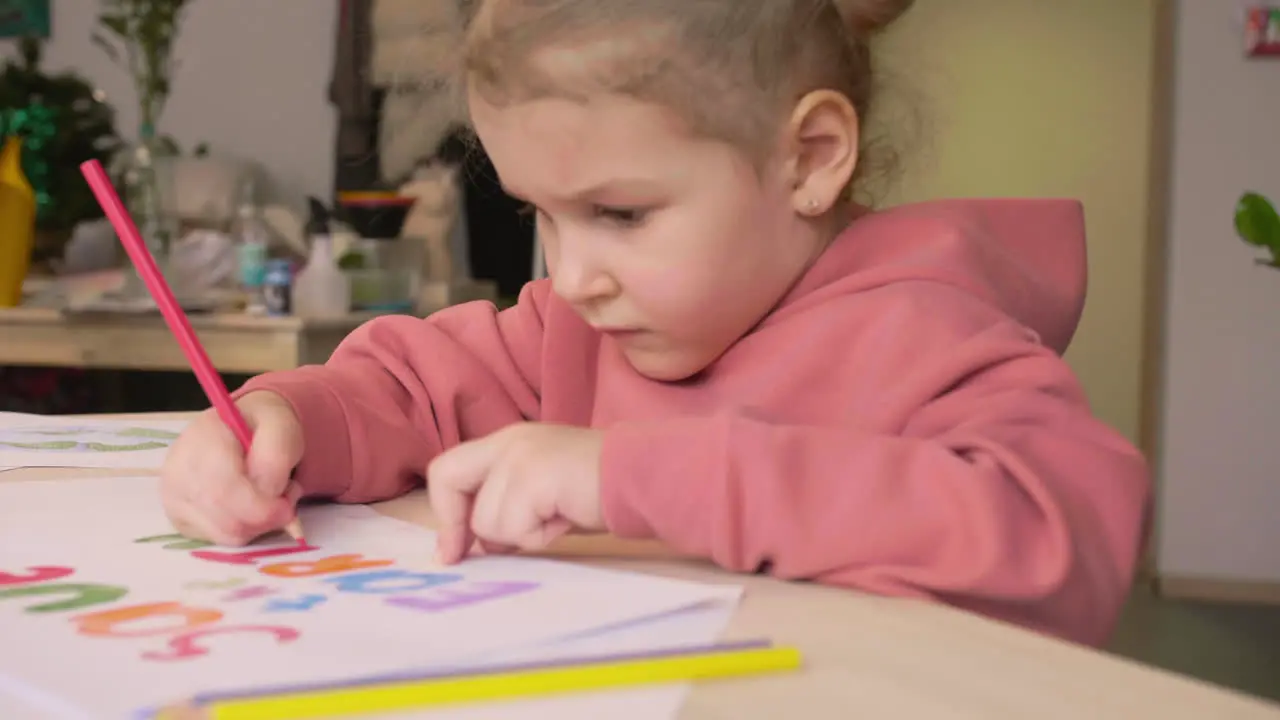 Niña Rubia Dibujando La Frase Salvar La Tierra En Un Papel Sobre Una Mesa En Un Taller De Artesanía