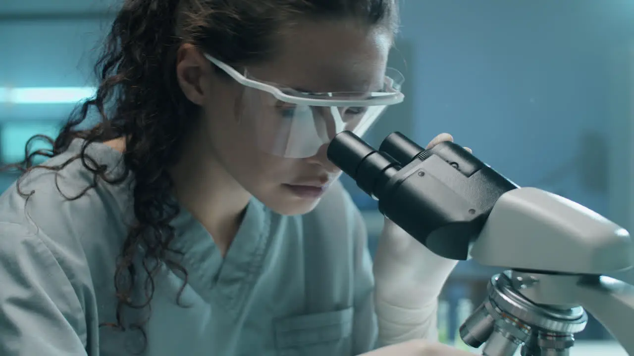 Biólogo Femenino Que Examina La Planta Con Microscopio En El Laboratorio