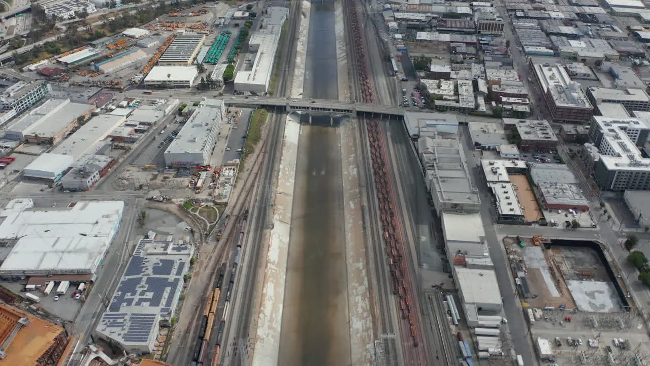 Antena El Río De Los ángeles Con Agua Inclinada Hacia Arriba Revelando La Carretera Y El Paisaje Urbano En El Cielo Nublado