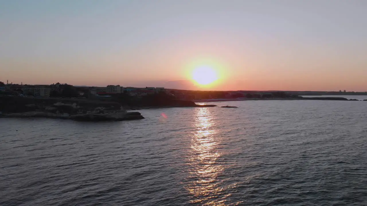 Aerial footage of sunset above the port Lozenets  Bulgaria filmed by drone flying down to the water