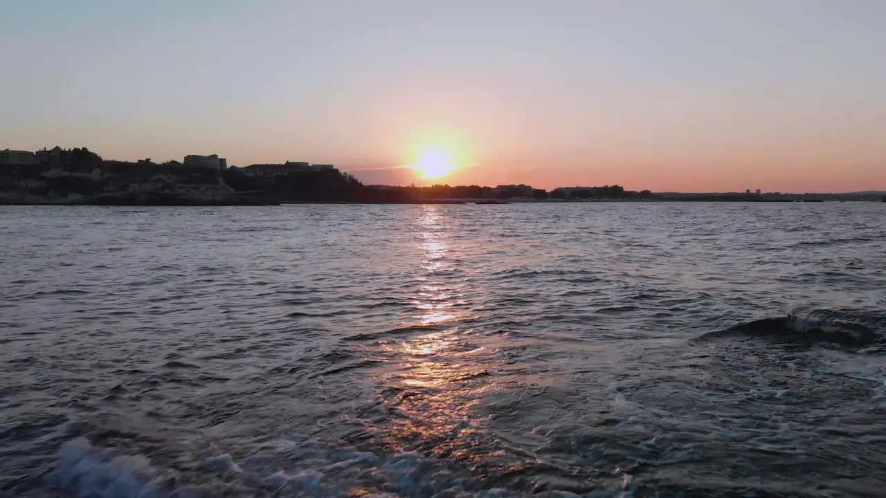 Aerial shot of sunset above the port Lozenets  Bulgaria filmed by drone flying towards the sun above the sea water