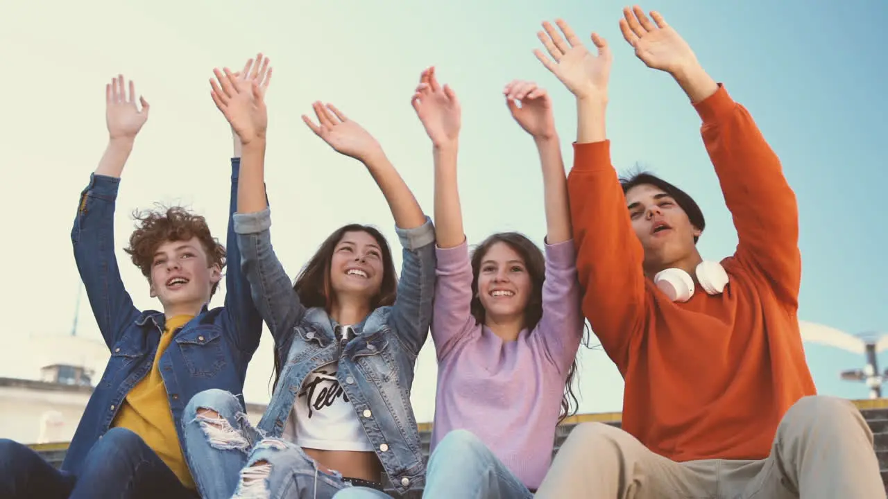 Un Grupo De Amigos Adolescentes De Dos Chicas Y Dos Chicos Levantan La Mano Y Bailan Con La Brújula 1