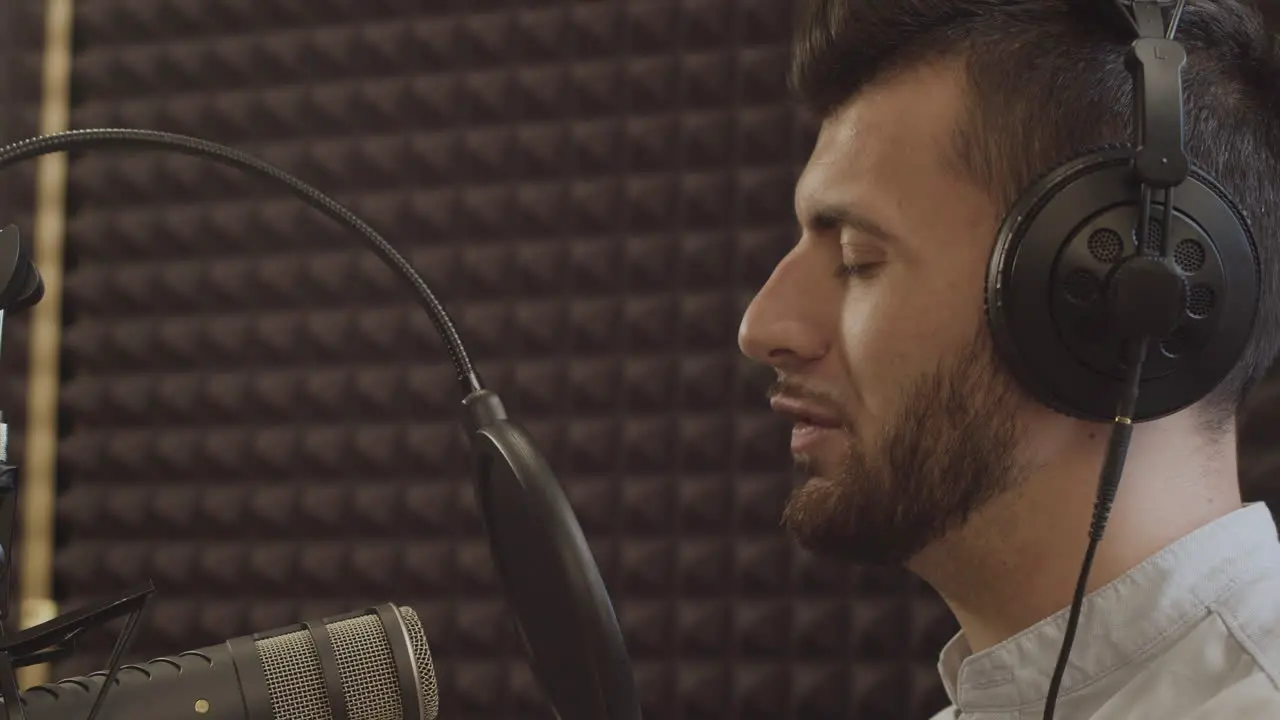 Primer Plano De Un Joven Presentador De Radio Con Barba Y Aparatos Ortopédicos Despidiéndose De Sus Oyentes Y Quitándose Los Auriculares