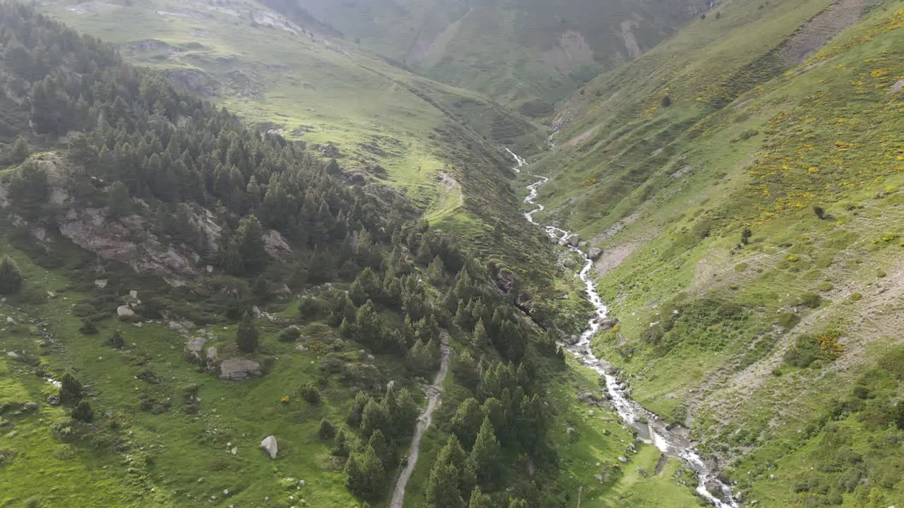 Toma Aérea De Un Hermoso Río Que Fluye Entre Las Verdes Laderas De Dos Montañas En Los Pirineos