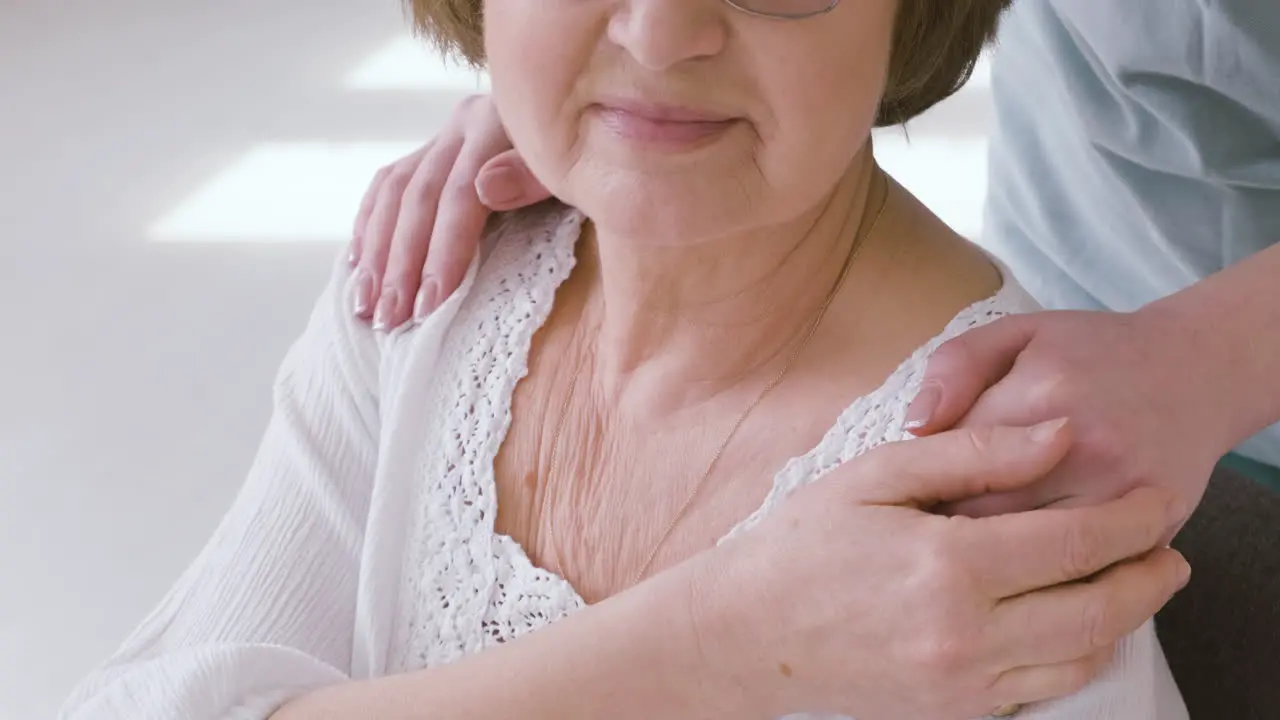 Anciana Sentada En Un Sofá Y Doctora Poniendo Las Manos Sobre Sus Hombros 1