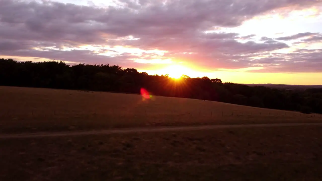 Moving towards a stunning sunset sky aerial shot over fields in Hitchin Hertfordshire England Uk