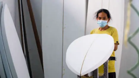 Handheld Long Shot of a Surfboard Shaper Looking at Polystyrene Board