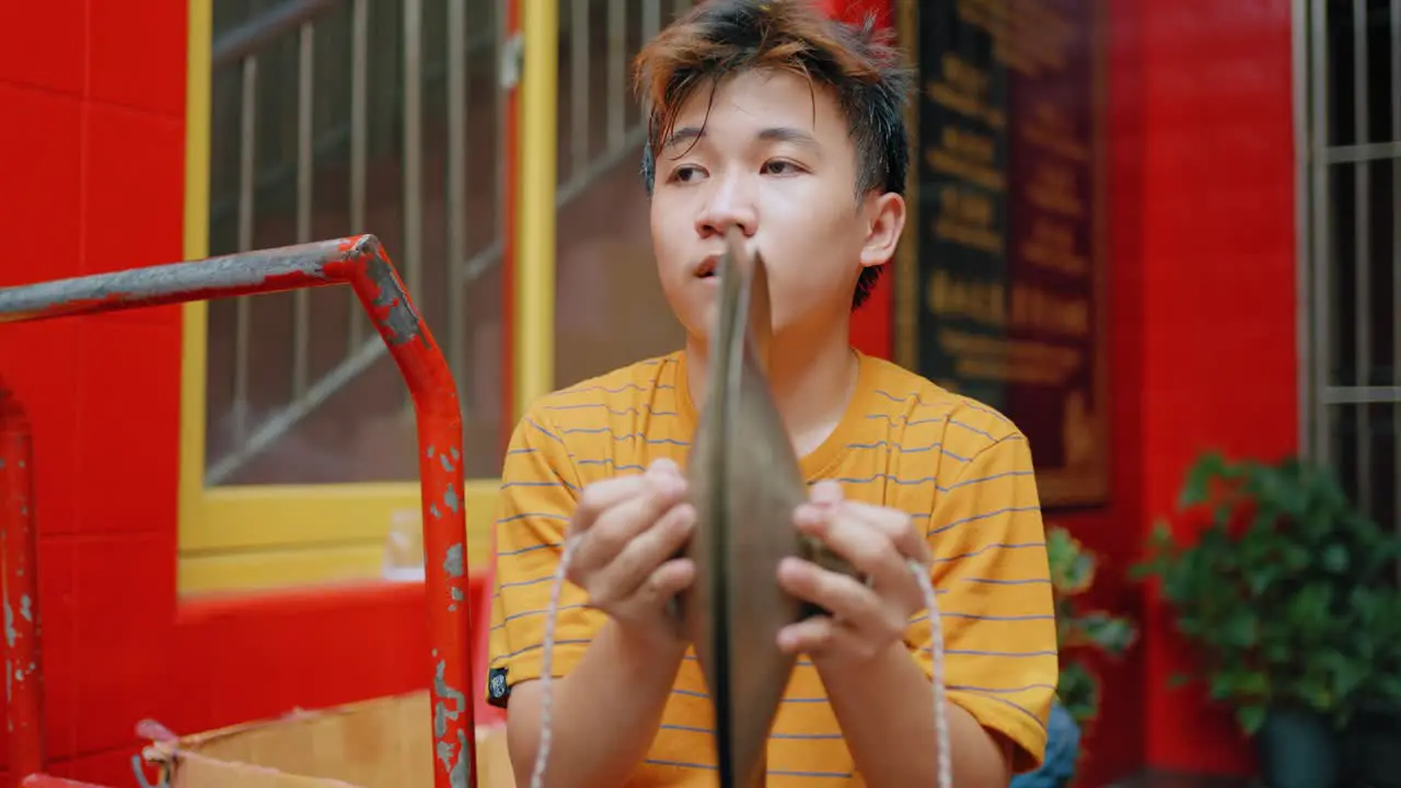 Tracking Shot of Boy Playing Instrument in Jakarta