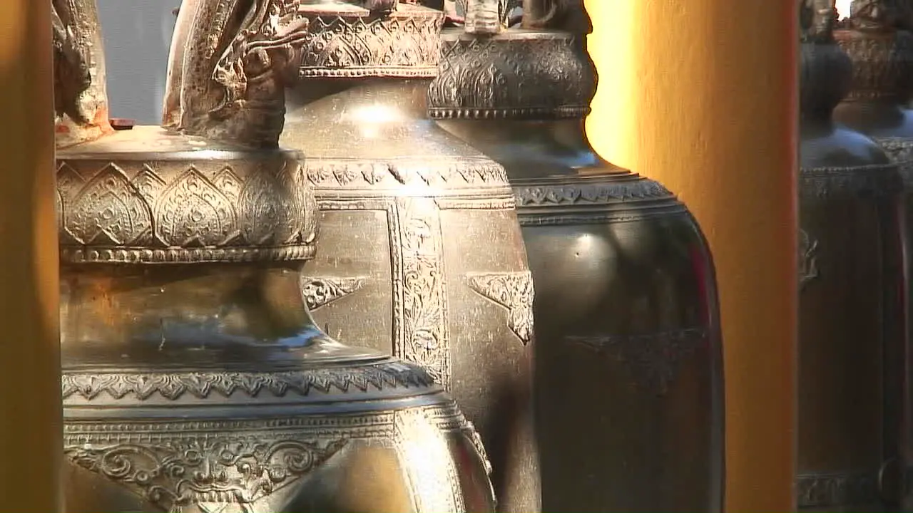 Ornate gold urns hang in a marketplace