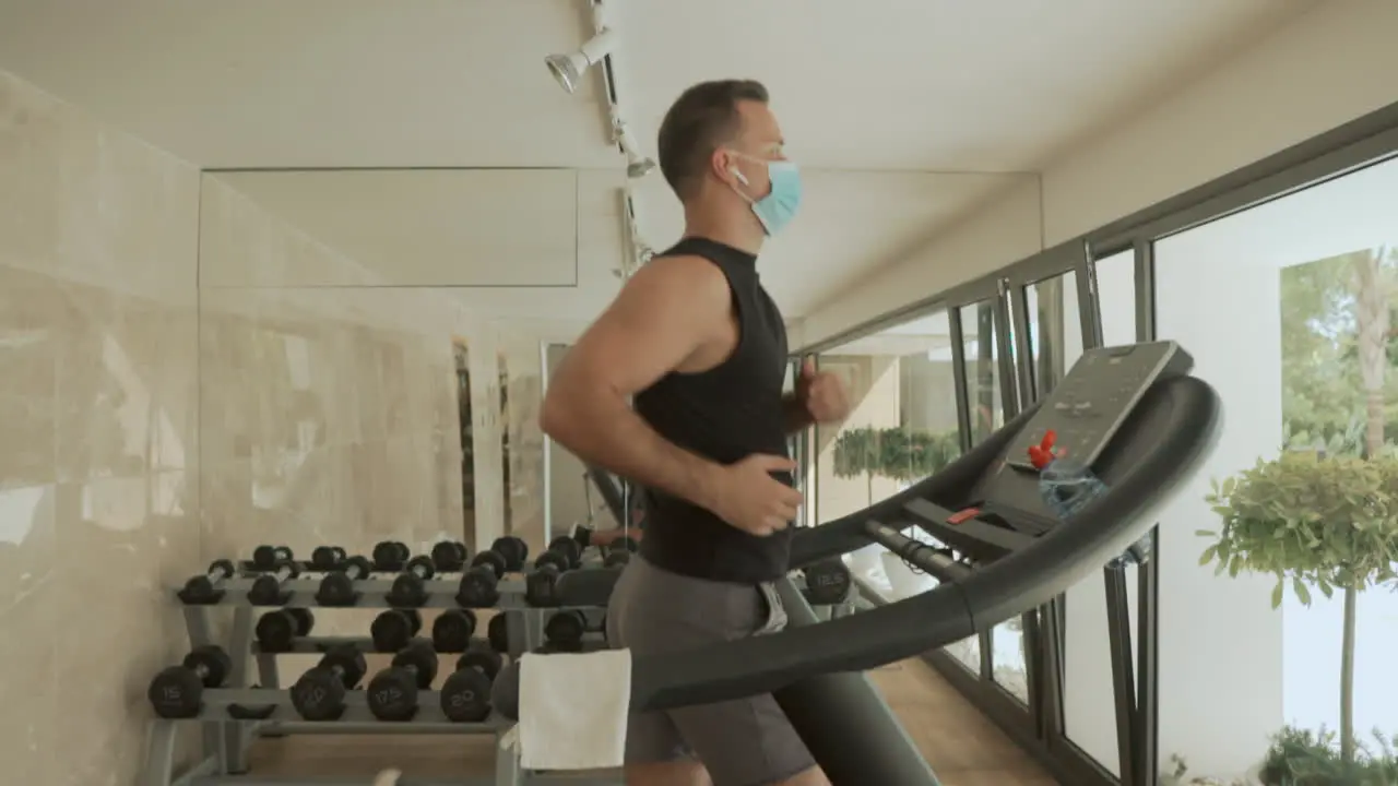 Athlete Male With Face Mask Uses Treadmill In The Gym