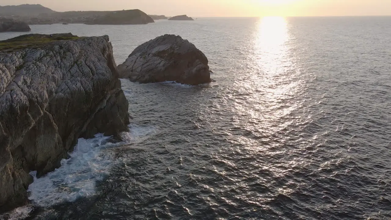 Aerial View Of Sea Waves Breaking On Rocky Shore At Sunset