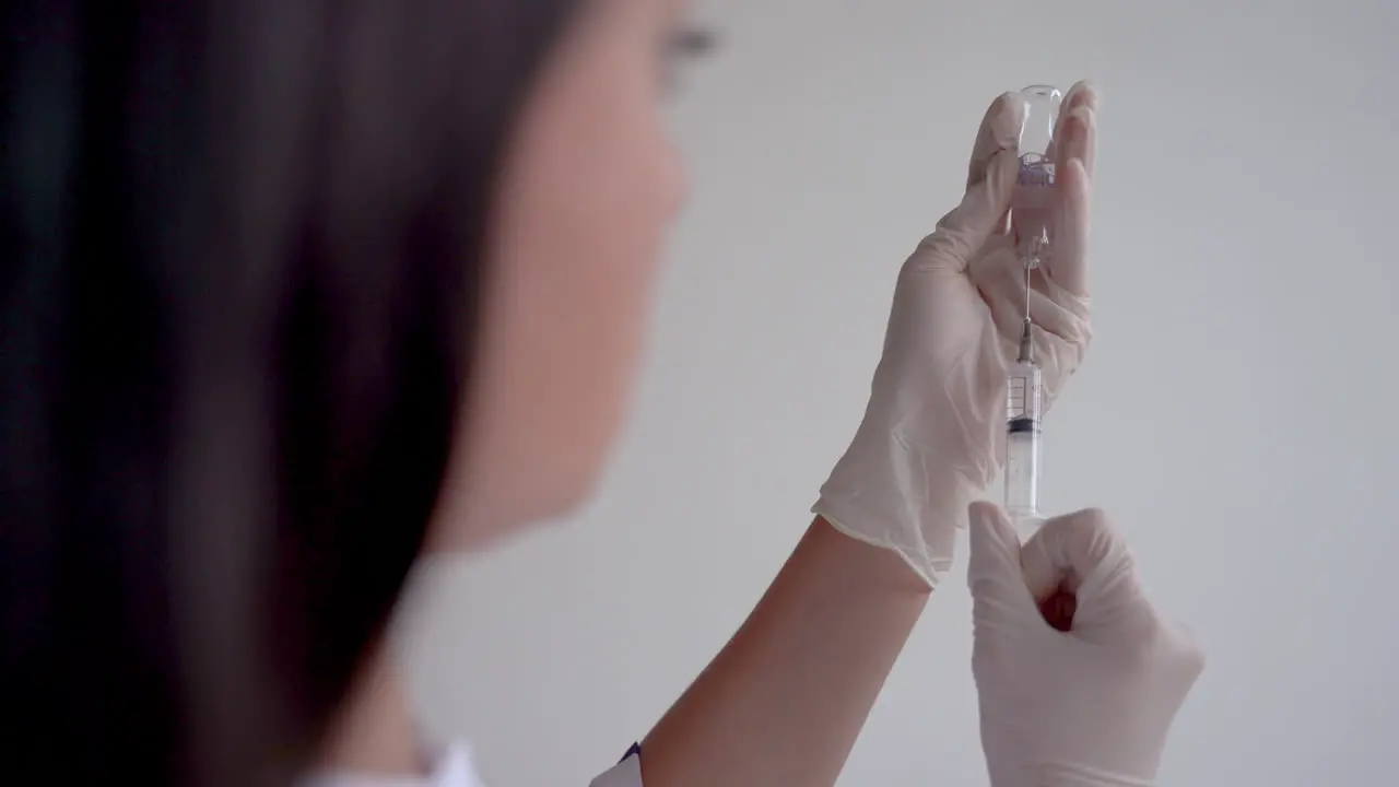 Close Up Of A Doctor Filling A Syringe With A Vaccine