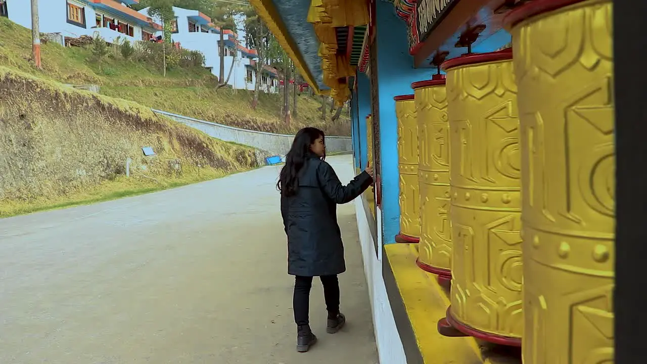 girl spinning Buddhism religious holy wheels at monastery from flat angle video is taken at bomdila monastery arunachal pradesh india