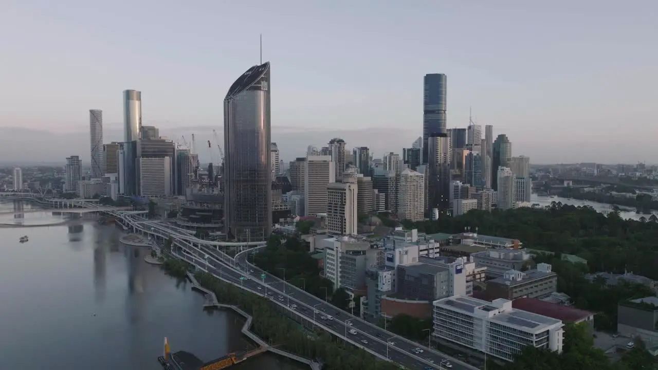 Cinematic Drone flying past Brisbane City looking towards Southbank Sunrise