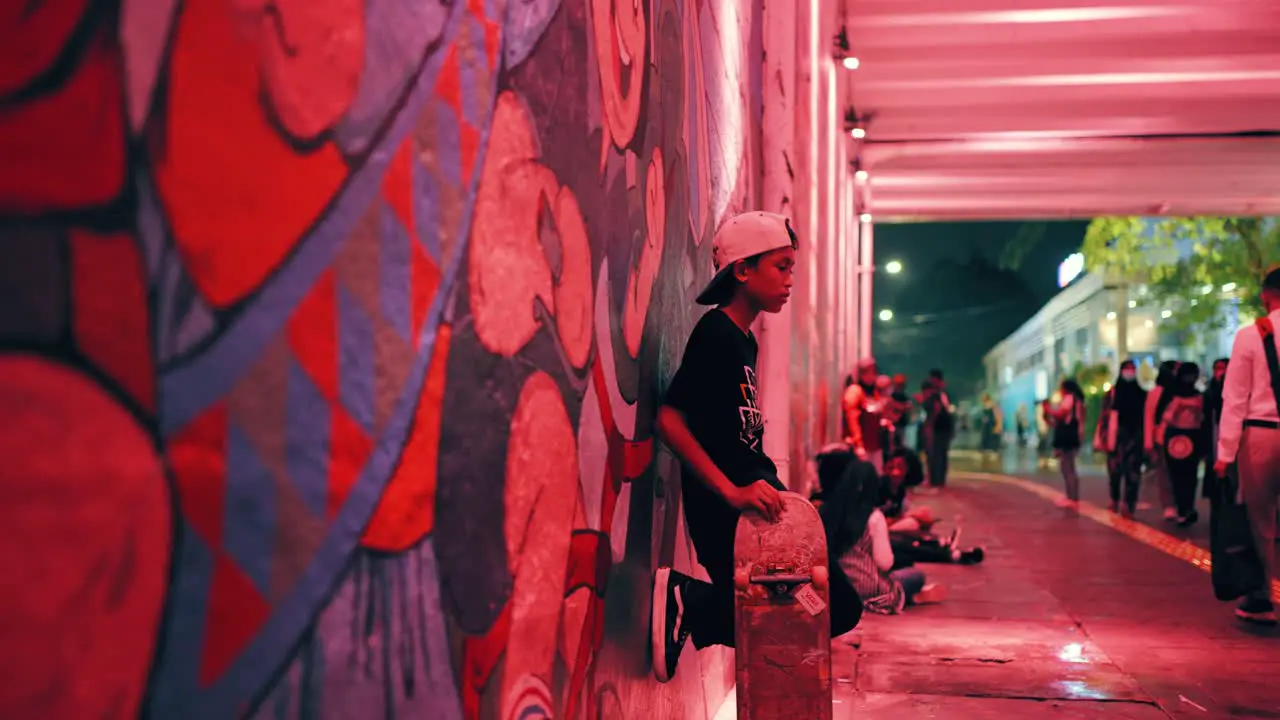 Tracking Shot of Boy Stood with Skateboard in Jakarta