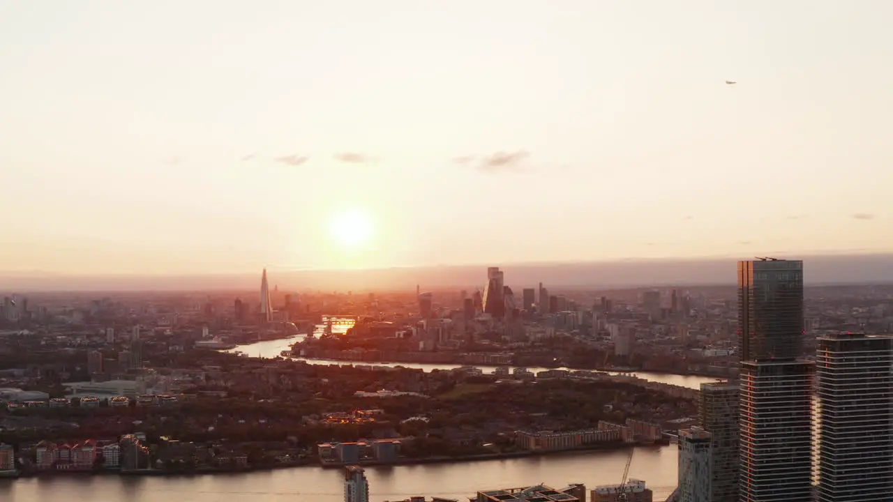 Romantic sunset above city Wide flow of River Thames winding through town Evening cityscape London UK