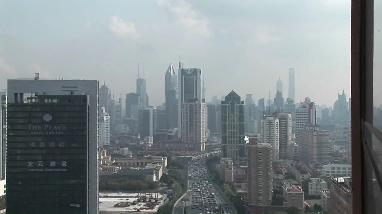 Vehicles drive on a freeway through a busy metropolis