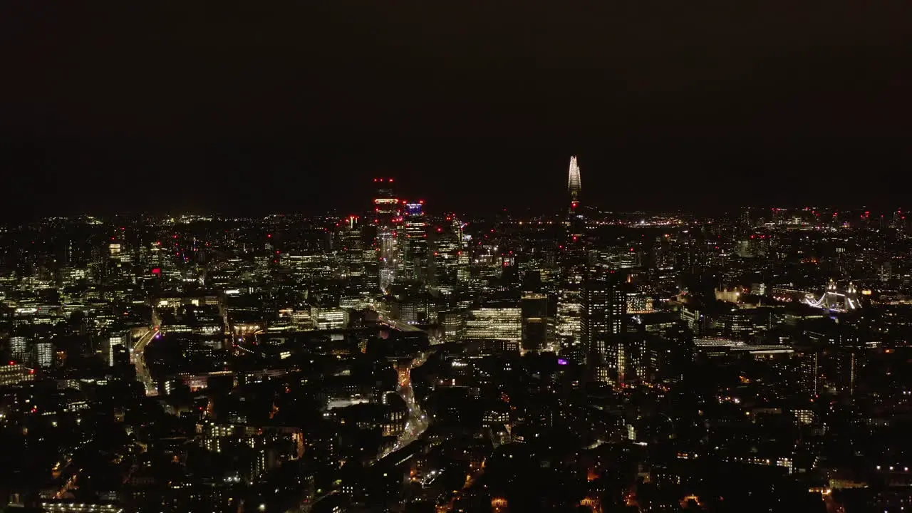 Aerial panoramic view of night cityscape Illuminated tall modern skyscrapers and downtown buildings London UK