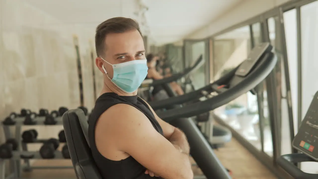 Young Strong Athlete Male Man With Face Mask Looking To Camera In The Gym