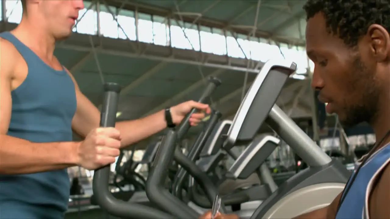 Fit man exercising in the gym with trainer