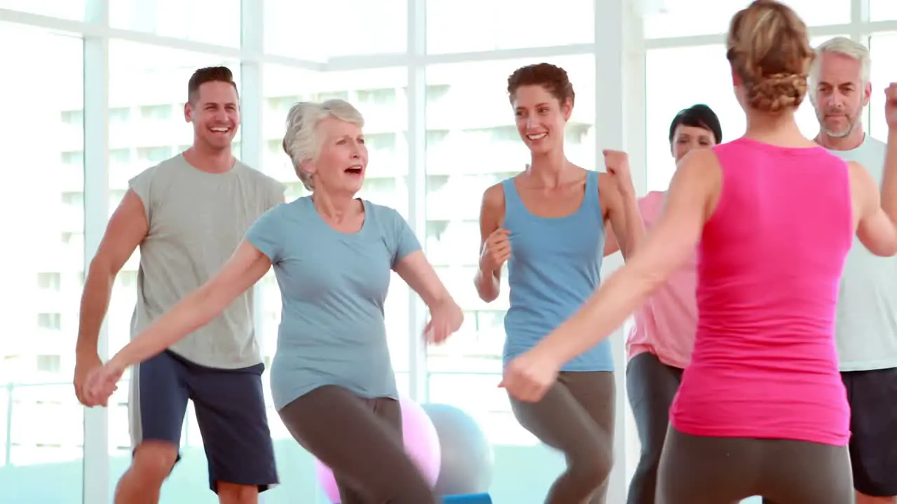 Aerobics class stepping and laughing together