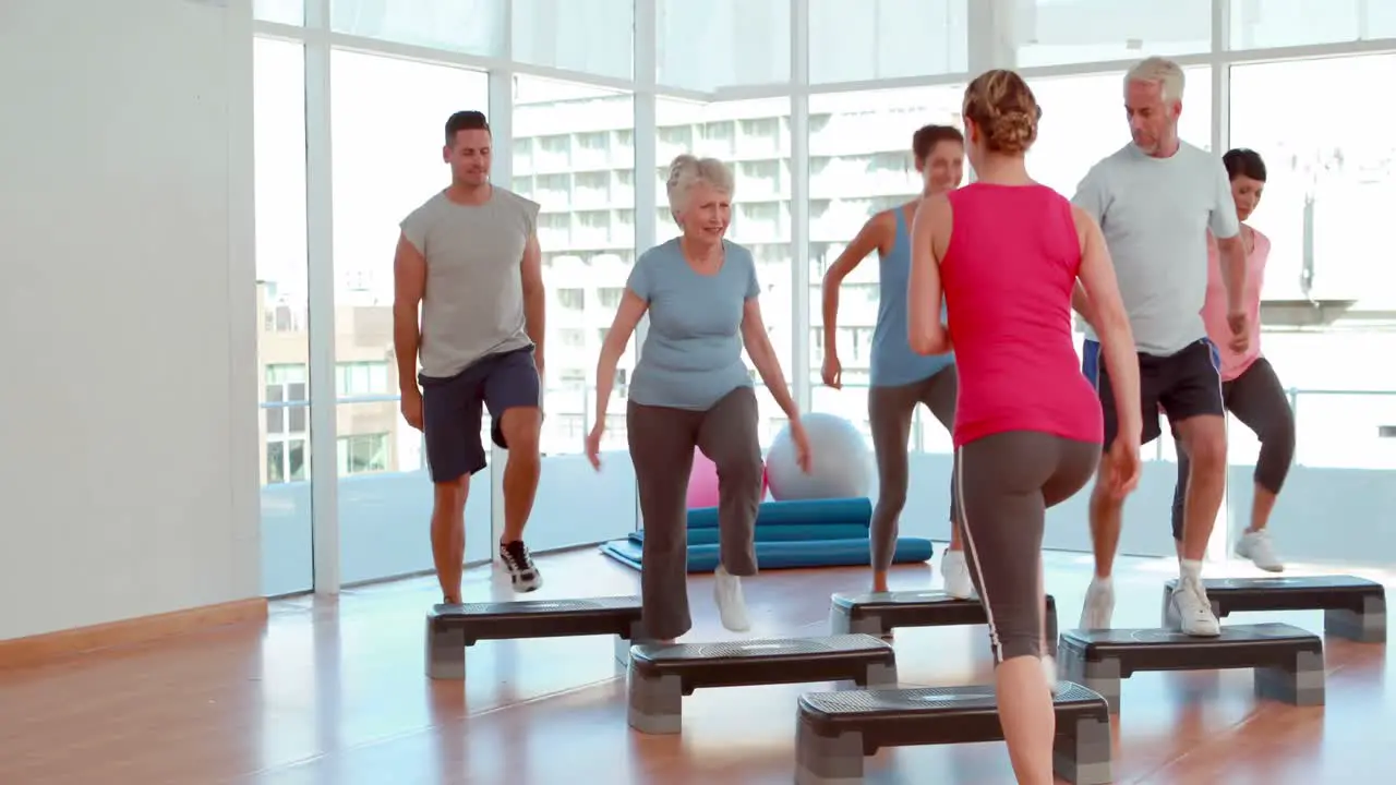 Aerobics class stepping and clapping together