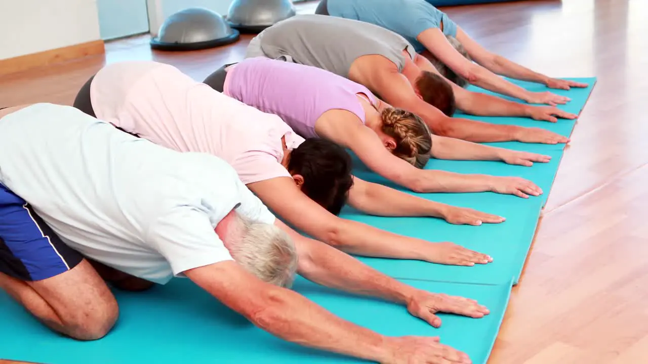 Yoga class in childs pose together