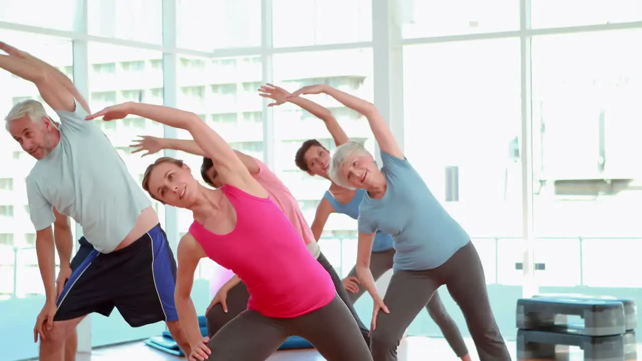 Aerobics class stretching their arms together