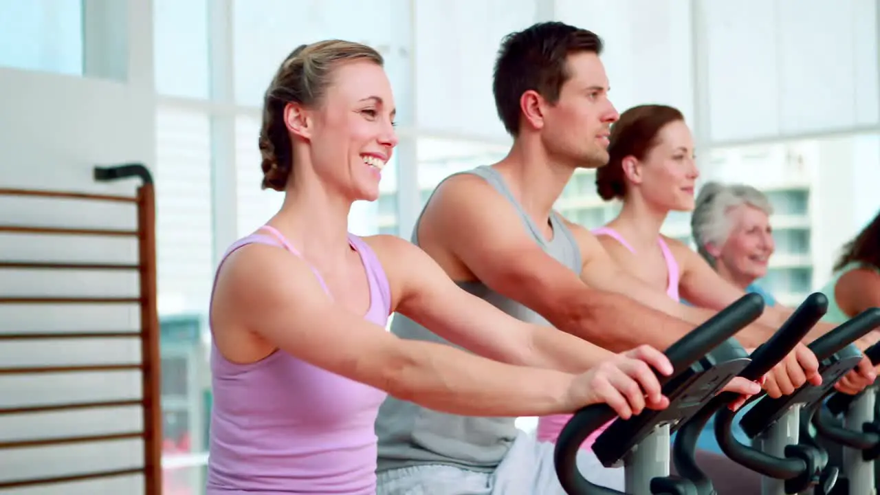 Happy fitness group doing a spinning class