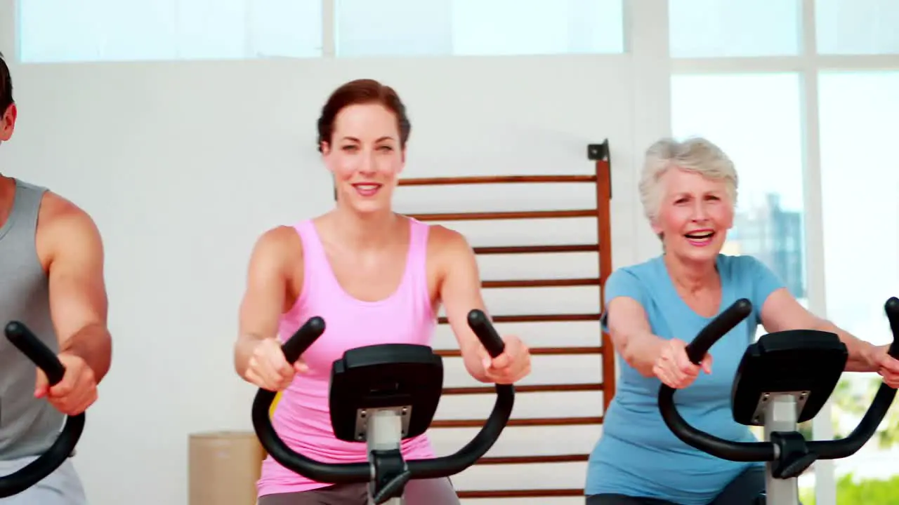 Happy diverse fitness group doing a spinning class