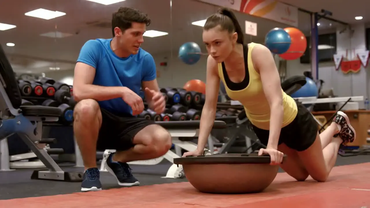 Woman doing push ups with trainer