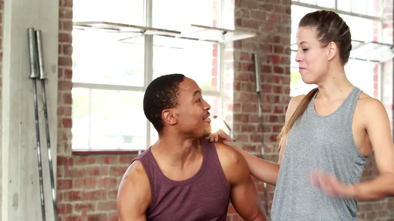 Fit couple chatting in gym