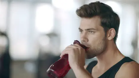 Thirsty man drinking water at sport training on gym workout