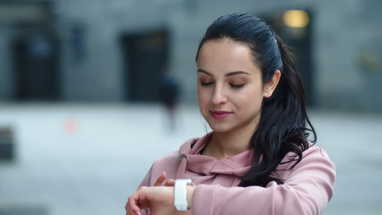 Close up pretty girl looking message on fitness watch in slow motion